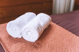 a stack of towels sitting on top of a bed at Comfortable Cosy Retreat in Rotorua