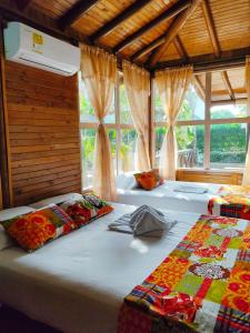 2 camas en una habitación con ventanas en Hotel Camino Verde en Tolú