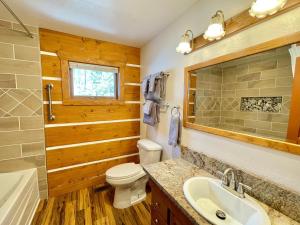 a bathroom with a toilet and a sink and a tub at Yosemite's Scenic Wonders - 6BR/4BA Tri-Level Home in Yosemite West