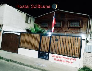 una señal frente a una casa con una puerta de madera en Hostal Sol y Luna en Santiago