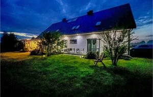 a white house with a bench in a yard at Nice Home In Smoldzino With Kitchen in Smołdzino