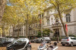 a group of cars and scooters parked in front of a building at Le Studio Du Parc Monceau in Paris