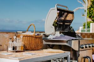 a grill with bottles and a basket on a table at Villa Blanca in Callao Salvaje