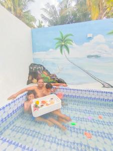 a woman and two children in a swimming pool at Mercy Cottage in Langgur