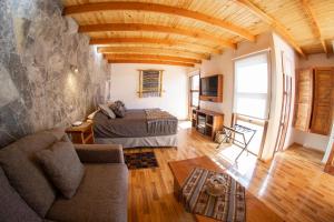 ein Schlafzimmer mit einem Bett und einem Sofa in einem Zimmer in der Unterkunft Lodge Quelana in San Pedro de Atacama