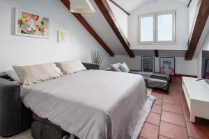 sypialnia z dużym łóżkiem i kanapą w obiekcie [Duomo - Pt.Romana - Bocconi] Top Floor Apartment w Mediolanie