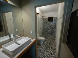 a bathroom with a sink and a toilet at El Reinas by Sugar's Monkey in Playa Grande