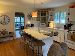 a kitchen with a kitchen island with bar stools at Auberge Old Chelsea in Chelsea