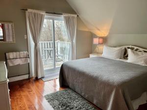 1 dormitorio con 1 cama y ventana con patio en Auberge Old Chelsea, en Chelsea