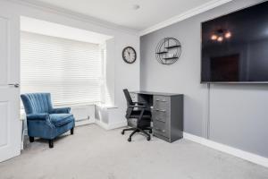 an office with a desk and a chair and a tv at TMS Cheerful 5BDR house! Thurrock! Free Parking! in Stanford-le-Hope