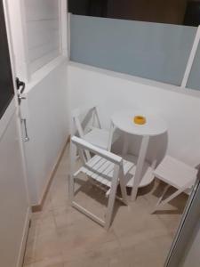 Casa y Estudio Keyfer, Arrecife Centro في أريثيفي: طاولة بيضاء وكرسي في غرفة