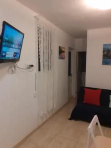 a living room with a couch and a tv on the wall at Casa y Estudio Keyfer, Arrecife Centro in Arrecife