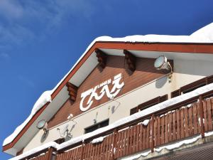 a building with snow on the top of it at Lodge Denbey in Nozawa Onsen