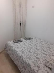 a bedroom with a bed with a white bedspread and a window at Casa y Estudio Keyfer, Arrecife Centro in Arrecife