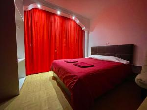 1 dormitorio rojo con 1 cama y cortina roja en Apartamento Adargoma tipo loft en Vecindario
