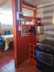 cocina pequeña con fogones y microondas en Cabaña Alba en Puerto Montt