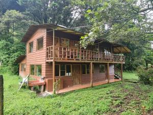a large wooden house with a porch and a deck at Finca Terra Viva in Monteverde Costa Rica