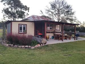 a small house with a patio and a picnic table at Spencer Lane Cottage & Granny Flat in Stanthorpe