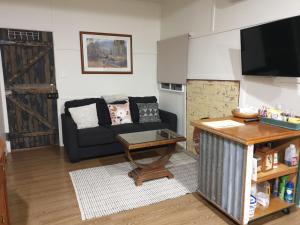 a living room with a couch and a table at Spencer Lane Cottage & Granny Flat in Stanthorpe