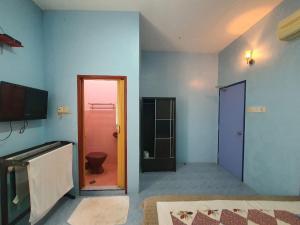 a room with a hallway with a door and a television at Deummah Guest Room in Cukai