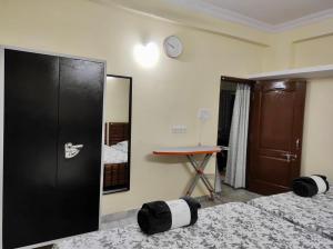 Cette chambre comprend deux lits et une horloge murale. dans l'établissement Home to explore Food, History & Shopping, à Hyderabad