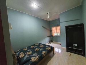 a bedroom with a bed and a flat screen tv at Homestay DeUmmah House in Cukai