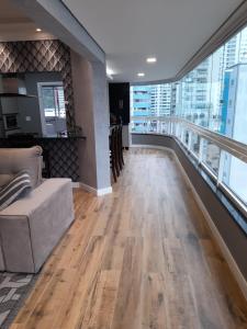 sala de estar con sofá y balcón en Belo apartamento reformado próximo a roda gigante, en Balneário Camboriú