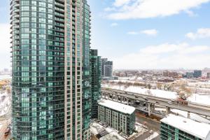 een hoog gebouw in een stad met een trein bij AOC Suites - High-Rise Condo - City View in Toronto