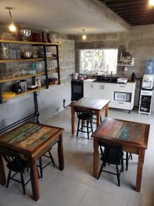 a kitchen with two wooden tables in a room at Moã do Mar Suítes in Guarda do Embaú +17 photos