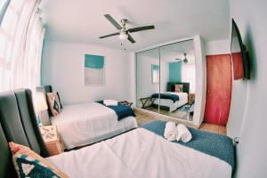 a bedroom with two beds and a mirror at Salinas House - The World’s favorite stay! in Salinas