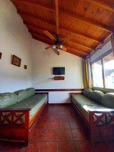 Habitación con 2 sofás y ventilador de techo. en Orillas del Mar, en Villa Gesell