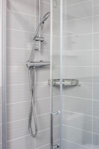 a shower with a shower head in a bathroom at TMS Cheerful 5BDR house! Thurrock! Free Parking! in Stanford le Hope