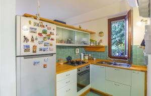 Una cocina con un refrigerador blanco y un fregadero. en Nice Home In Marina Di Modica With Wifi, en Marina di Modica