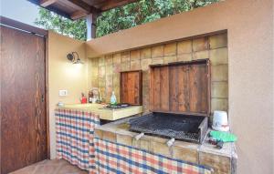 una cocina al aire libre con barra y parrilla en Nice Home In Marina Di Modica With Wifi, en Marina di Modica 10 fotos más