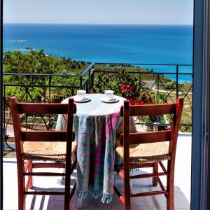 a table with two chairs and a view of the ocean at Aeolos Studios Kefalonia in Khelmáta