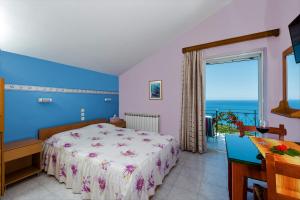 a bedroom with a bed and a view of the ocean at Aeolos Studios Kefalonia in Khelmáta