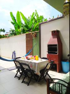 a table and chairs on a patio with a pizza oven at Casa Próximo ao Centro in Paraty