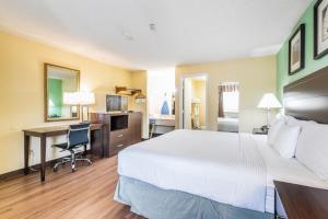 a hotel room with a bed and a desk at Days Inn by Wyndham Federal Way in Federal Way