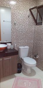 y baño con aseo, lavabo y espejo. en Maravilhoso Apt 109 Home Service próximo Shopping Partage e Rodoviária en Campina Grande