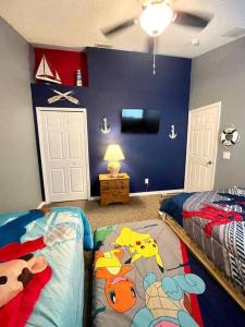 1 dormitorio con 2 camas y pared azul en Luxury Disney Family Villa (5-Bedroom, pool & spa) en Kissimmee