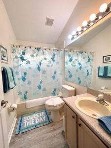 y baño con aseo y lavamanos con cortina de ducha. en Luxury Disney Family Villa (5-Bedroom, pool & spa), en Kissimmee