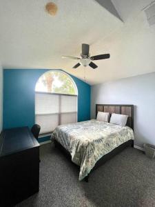 1 dormitorio con 1 cama y ventilador de techo en Luxury Disney Family Villa (5-Bedroom, pool & spa) en Kissimmee