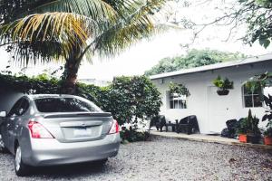 um carro estacionado em frente a uma casa com uma palmeira em Habitacion Fuego - Villa Valle Campo 