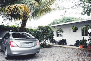 a car parked in front of a house with a palm tree at Habitacion Fuego - Villa Valle Campo 