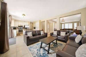 Una sala de estar con sofás y una mesa y una cocina. en Pool-BBQ-View-Balcony-Fireplace-King-Garage-WD, en Lake Elsinore