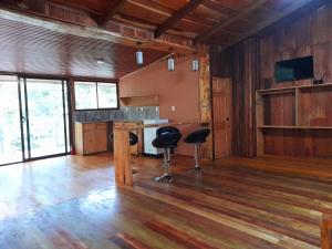 a large room with a bar and two stools in it at Cabañas La Montaña Mountain Lodge in Monteverde Costa Rica