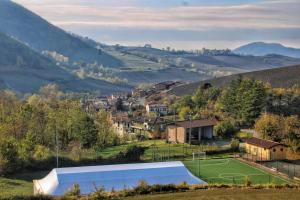 a tennis court in the middle of a valley with a town at Il Posticino D'oltrepò in Calghera