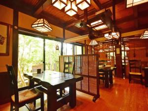 a dining room with a wooden table and chairs at Hotakajo in Azumino