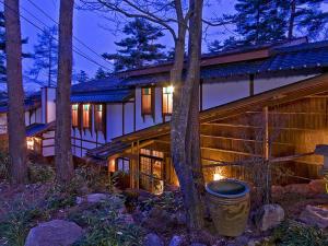 una gran casa de madera en el bosque por la noche en Hotakajo, en Azumino