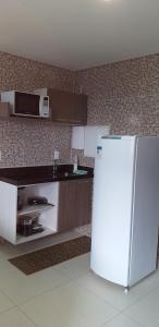a kitchen with a white refrigerator and a microwave at Maravilhoso Apt 109 Home Service próximo Shopping Partage e Rodoviária in Campina Grande